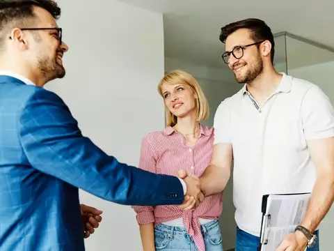 Poignée de main entre un courtier et un couple d'acheteurs