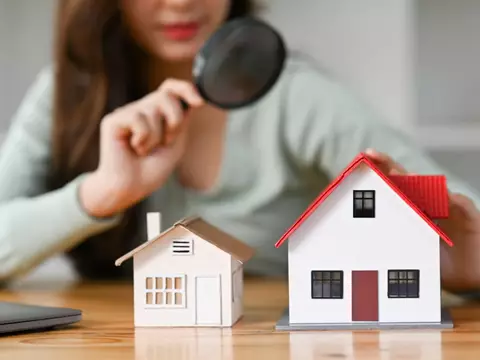 Examen d'une maquette de maison à la loupe